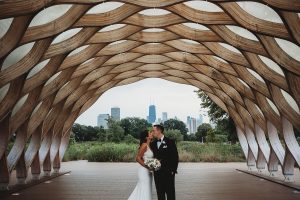 bride and groom kissing under the honeycomb with the Chicago skyline behind them