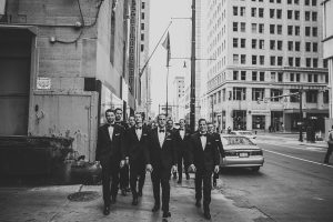 groom and groomsmen walking in detroit in their suits