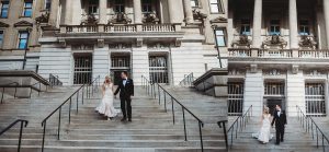 bride and groom walking down the stairs holding hands and laughing in detroit