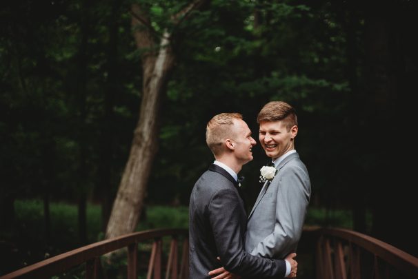 two grooms laughing and hugging wedding photos
