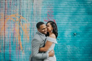 bride and groom laughing in front of a mural detroit mi elopement