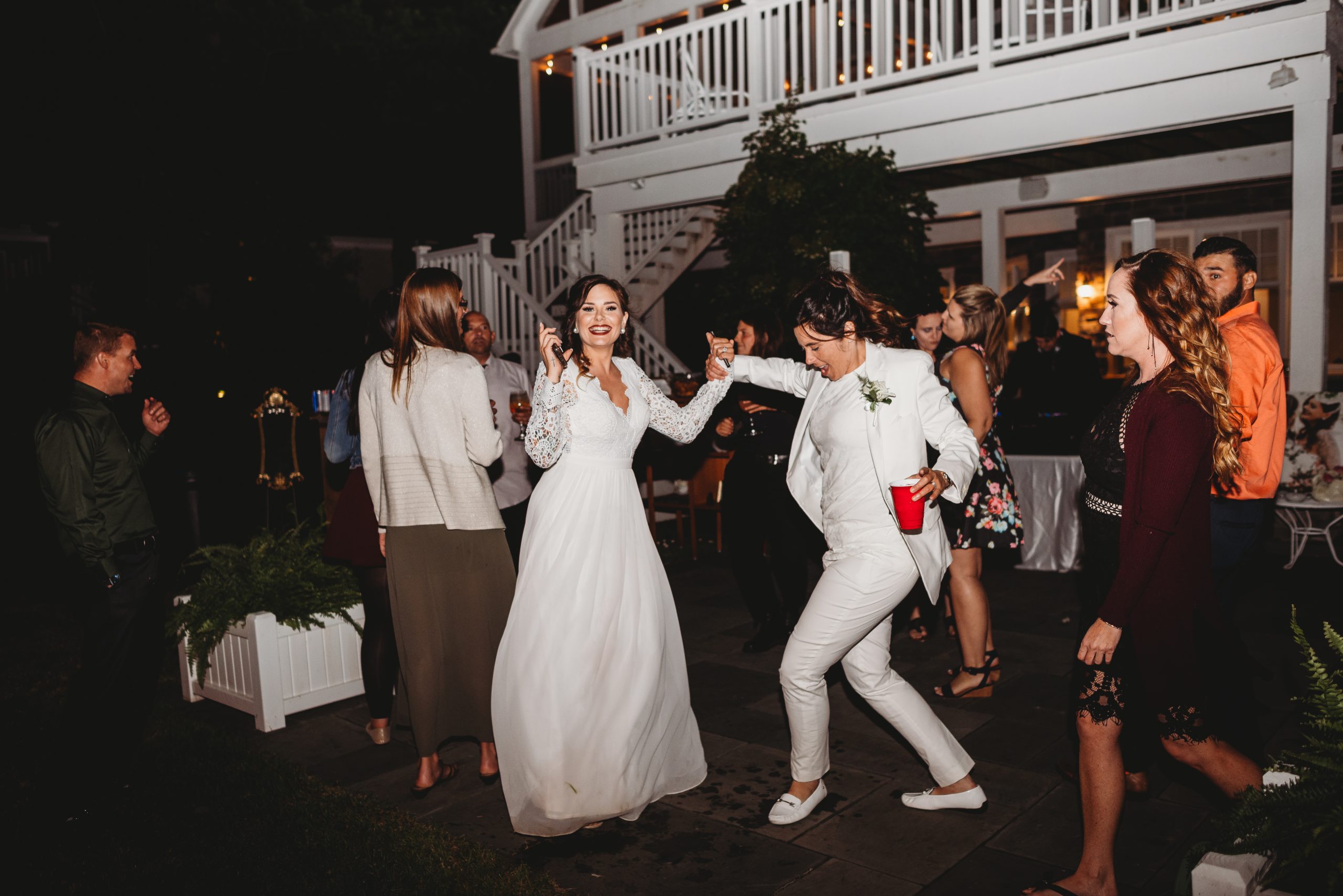 two brides dancing at their backyard wedding reception