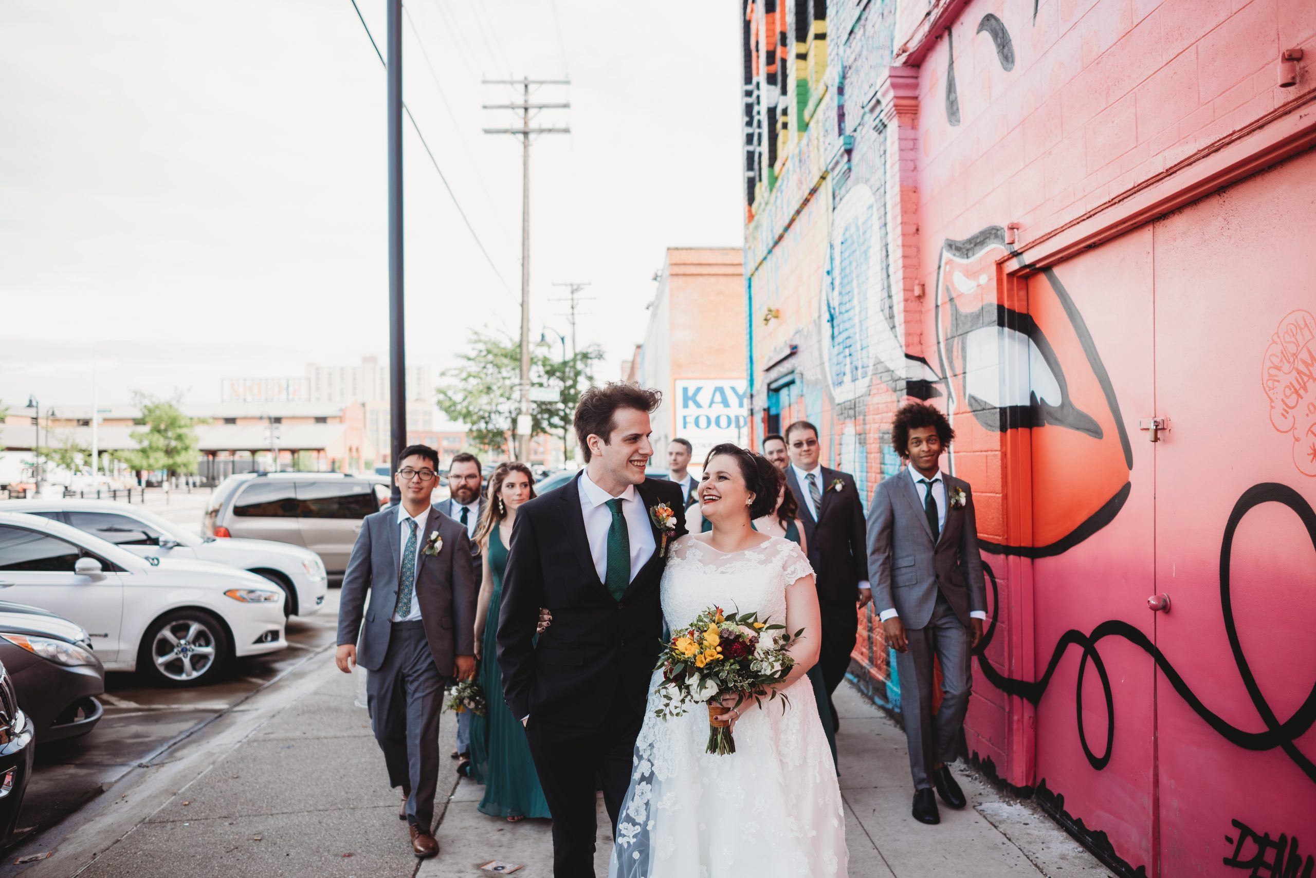 wedding party walking and laughing in eastern market detroit