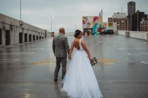 bride and groom walking in the rain on the Z lot roof top detroit mi