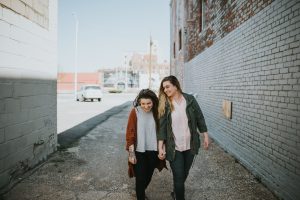 same sex couple walking and laughing in eastern market Detroit mi