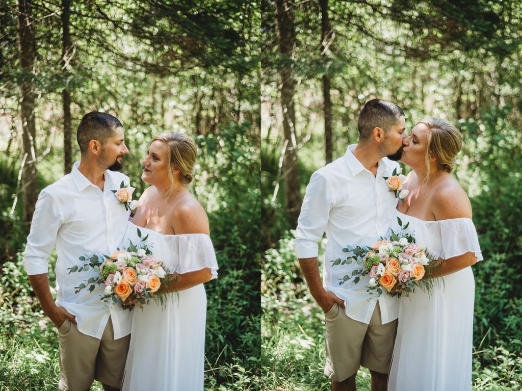 bride and groom kissing and smiling in the woods in northern michigan