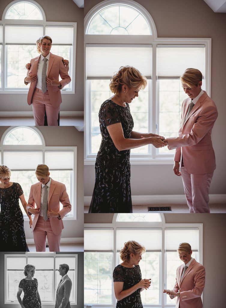 mom helping daughter get dressed in her pink suit on her wedding day