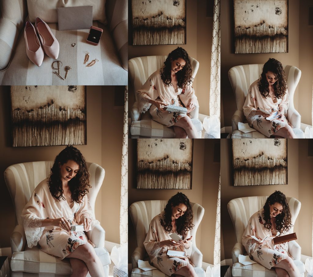 bride in her floral robe opening a gift and smiling