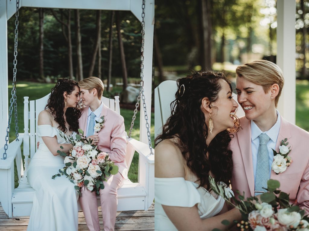 bride in a pink suit and bride in a white dress cuddling and kissing on a white garden swing holding pink and white wedding flowers 