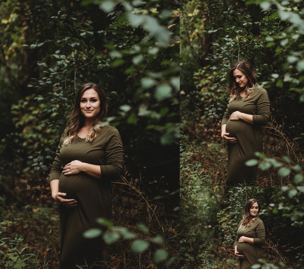 pregnant mom in a green dress holding her belly and smiling in the woods