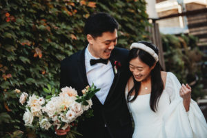 Asian newly weds bride and groom walking, smiling and laughing at their wedding reception.